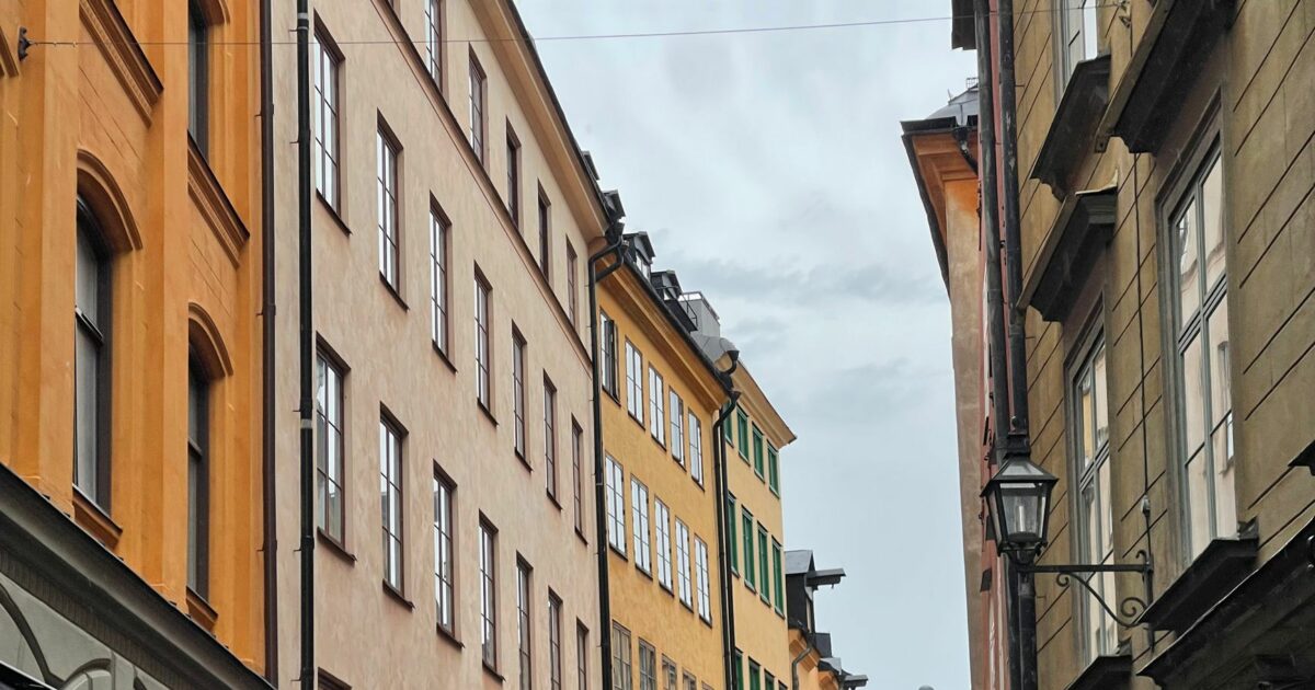 Tät stadsbebyggelse i Stockholm där varje fastighet gränsar tätt till nästa, vilket påverkar möjligheterna att utföra underhållsarbeten på avloppsledningar.