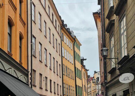 Tät stadsbebyggelse i Stockholm där varje fastighet gränsar tätt till nästa, vilket påverkar möjligheterna att utföra underhållsarbeten på avloppsledningar.